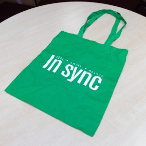 Green INSYNC bags with white printed letters