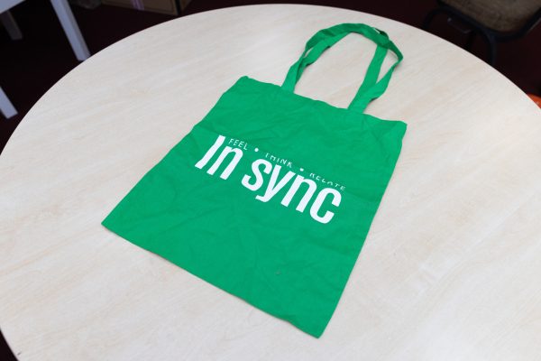 Green INSYNC bags with white printed letters