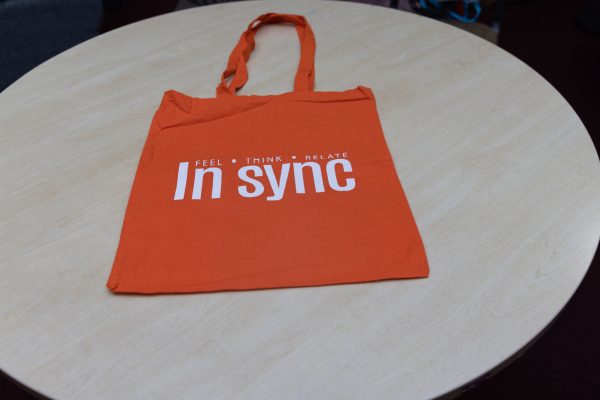 Image of Orange INSYNC bags with white printed letters